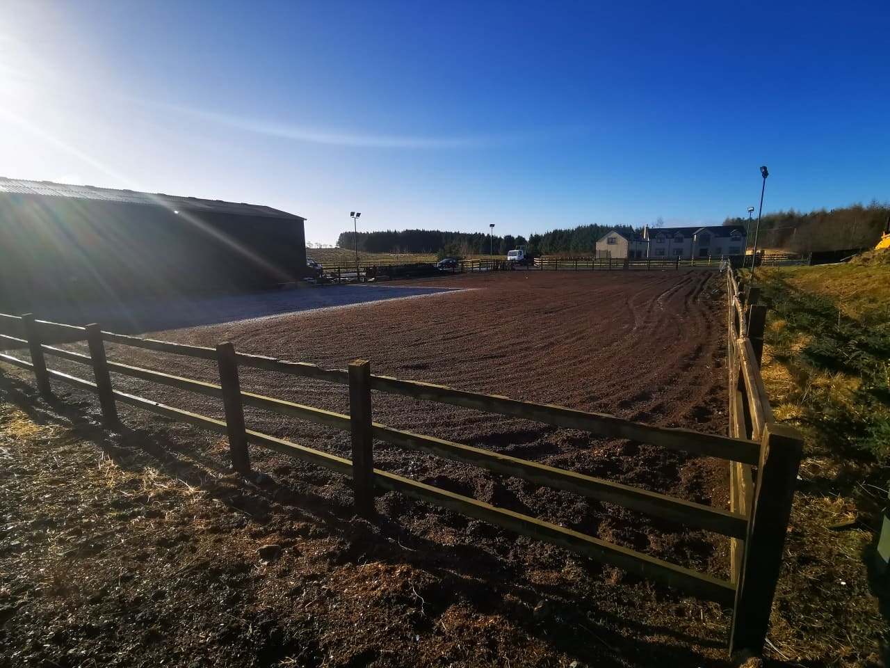 The outdoor arena and paddock fencing at The Crofts on a clear winter morning
