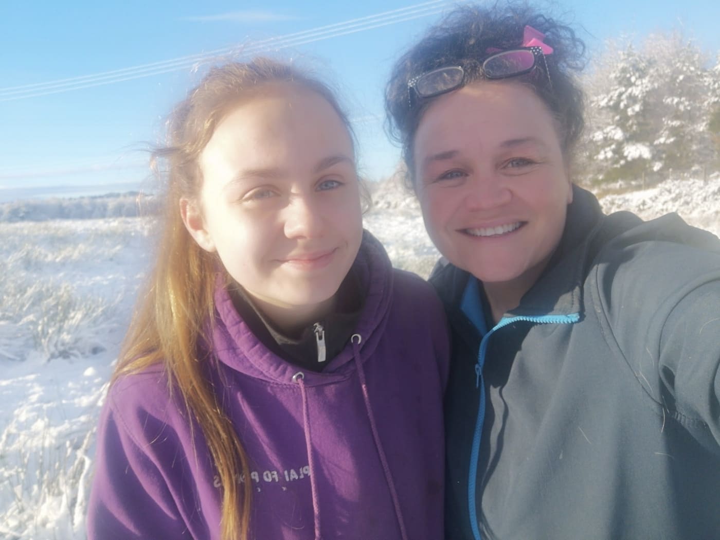 Angela and Gracie smiling together in a snow-covered field